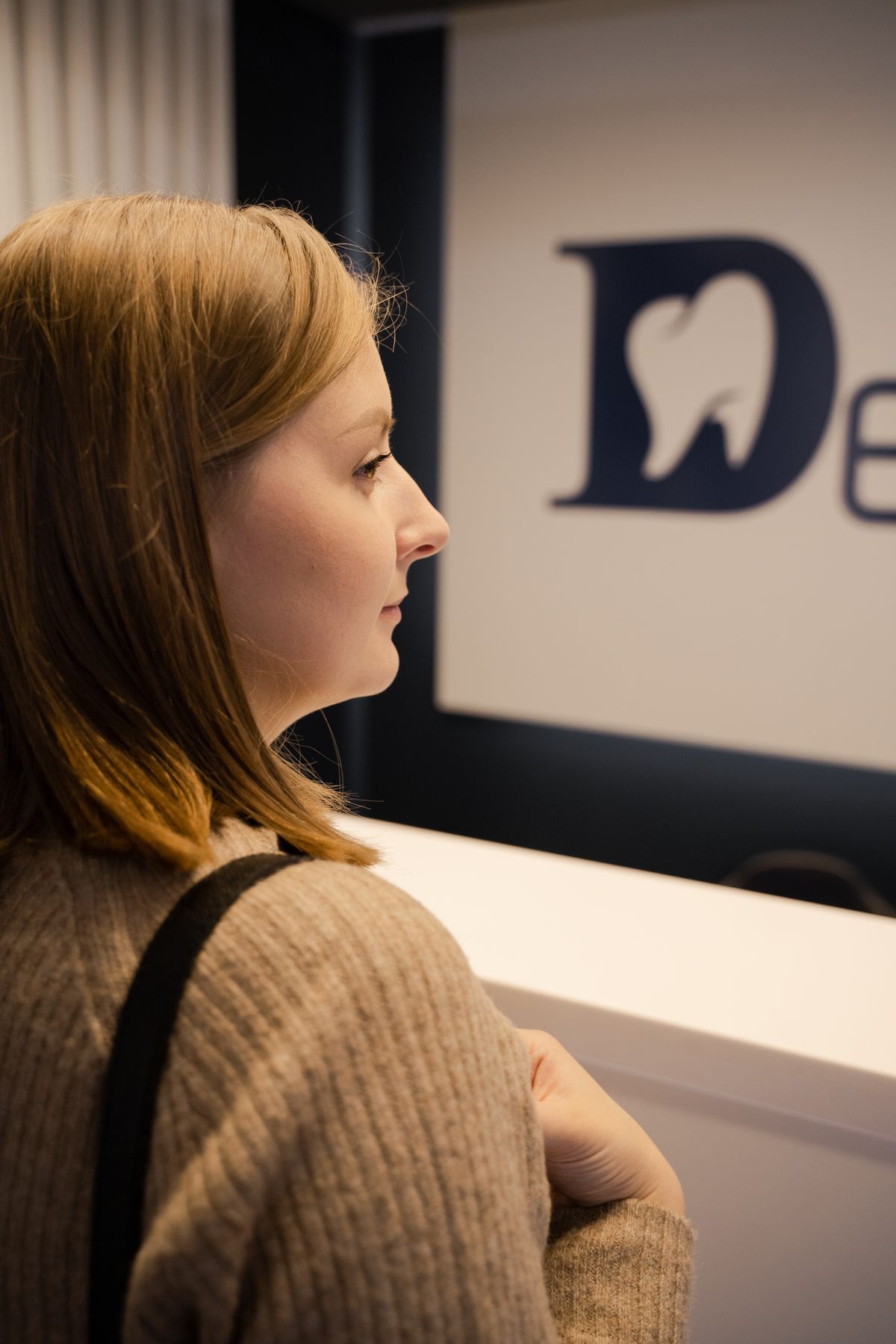 Woman standing at a dental office reception desk
